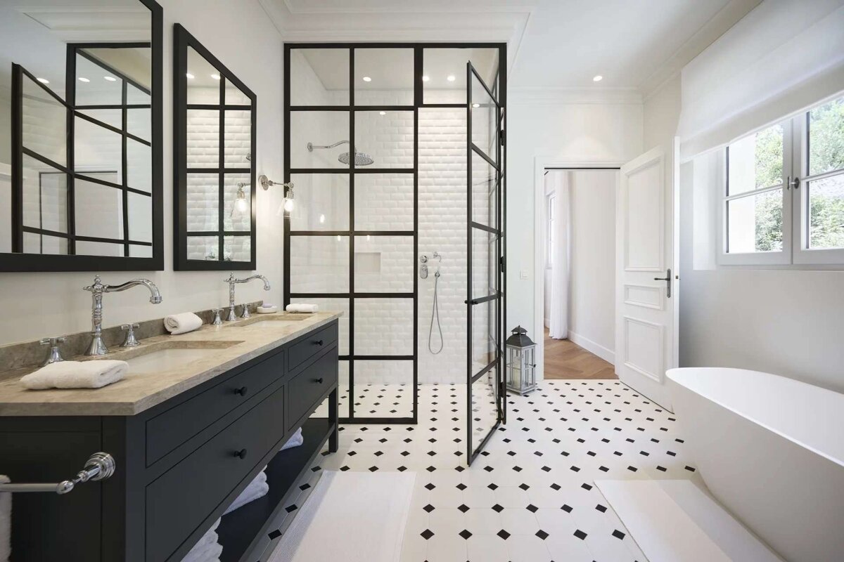 Modern black & white bathroom with a grid shower, double vanity, geometric floor tiles, and a sleek white tub.