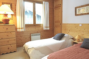 A bedroom with two beds and a dresser