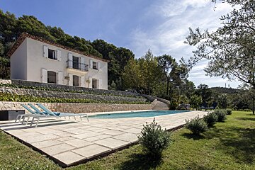 A large white house with a swimming pool in front of it