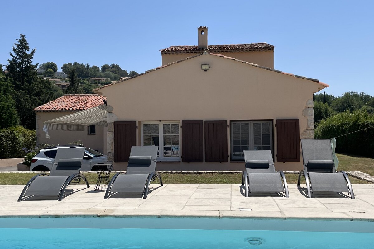 A house with a swimming pool in front of it