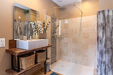 A bathroom with a sink and a walk in shower