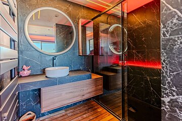 A bathroom with a round mirror and a sink