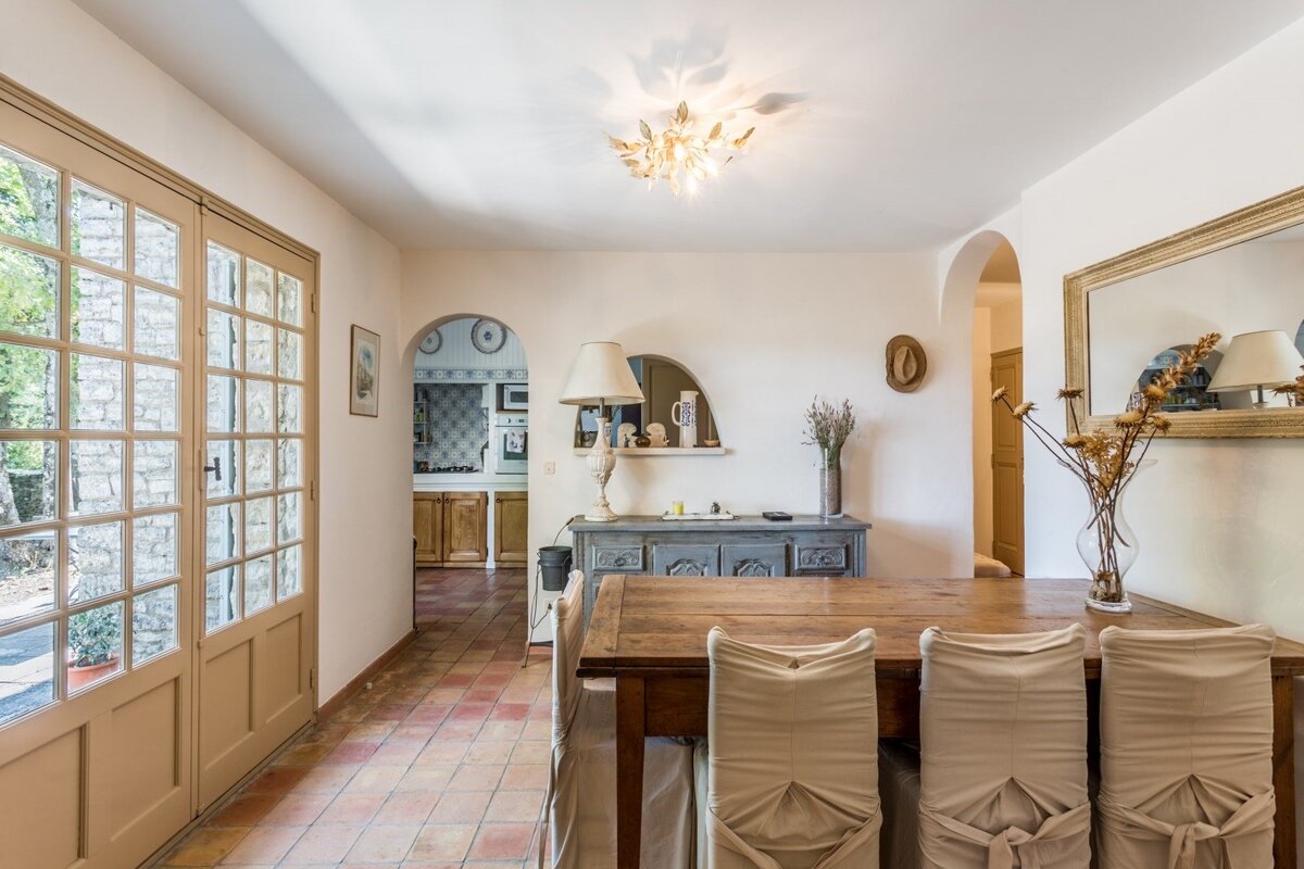 A dining room with a table and chairs and a mirror
