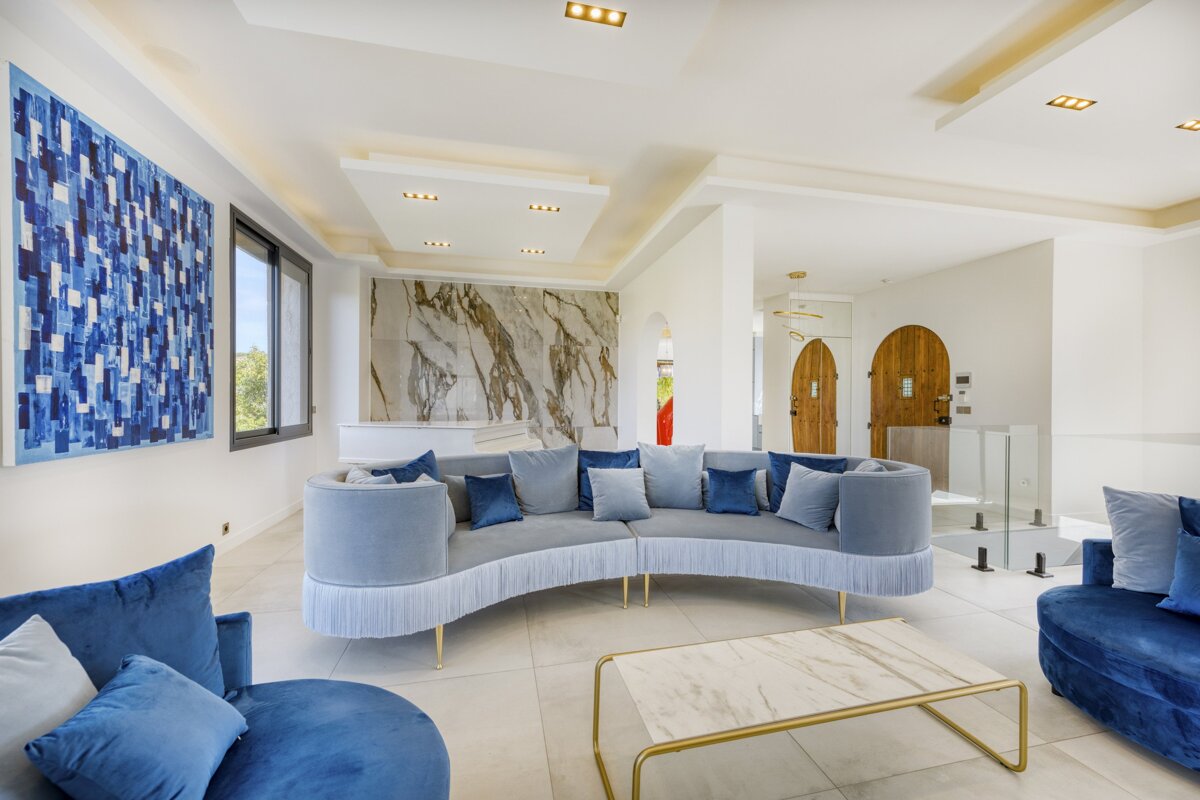 A living room with a curved couch and blue chairs