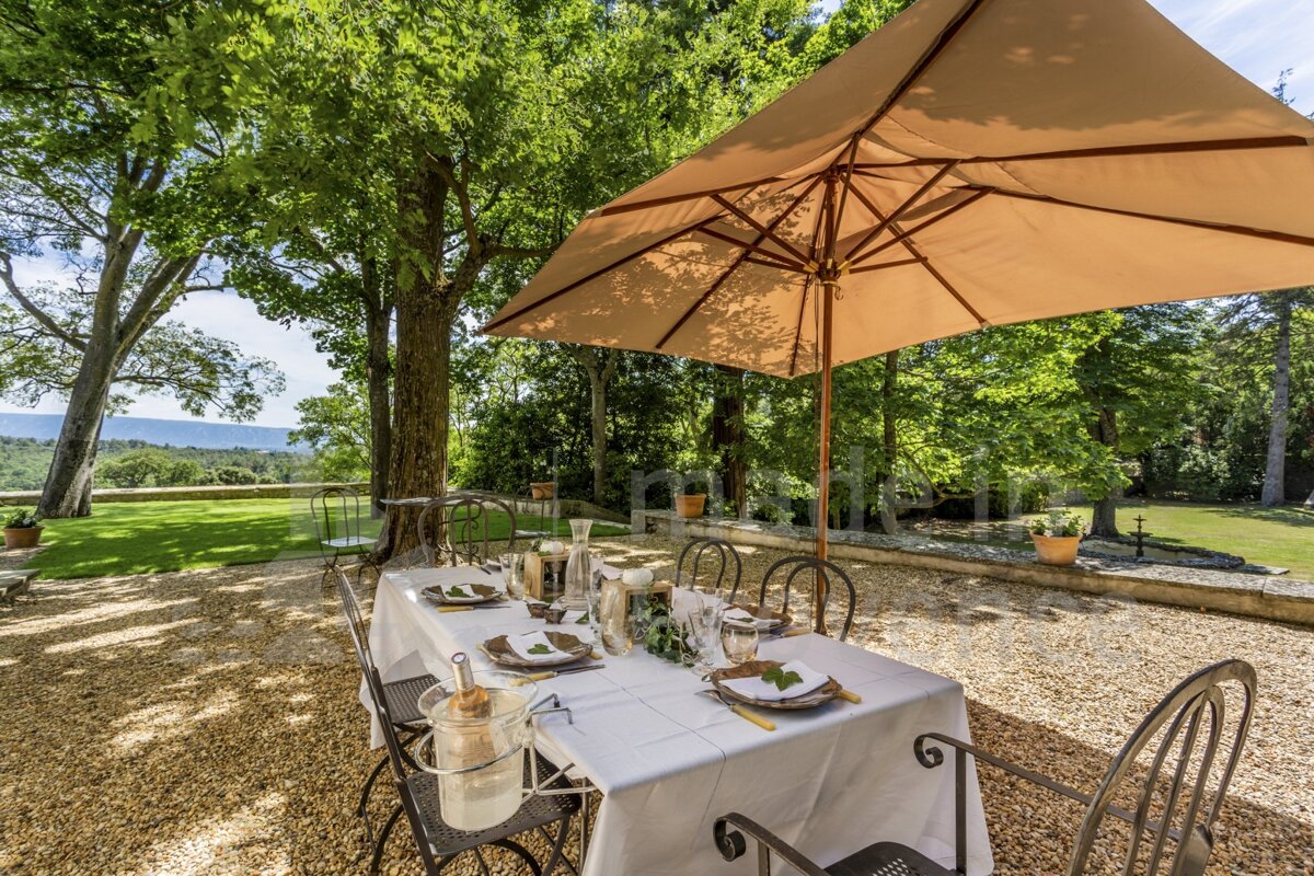 A table with plates and glasses under an umbrella