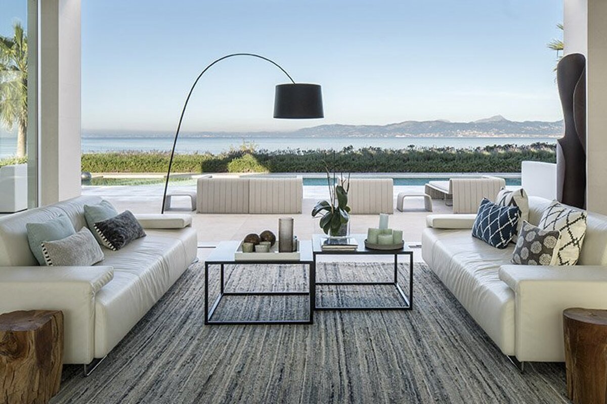 A living room with a view of the ocean and mountains