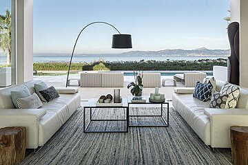 A living room with a view of the ocean and mountains