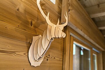 A wooden deer head hanging on a wooden wall