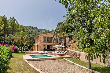 A large house with a swimming pool in front of it