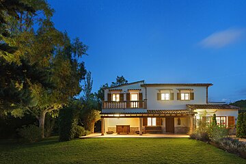 A house with a lush green lawn in front of it