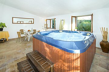 A hot tub in a room with a table and chairs
