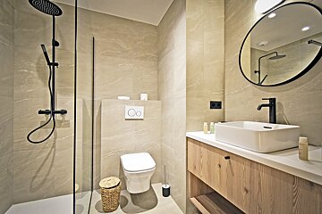A bathroom with a toilet a sink and a shower