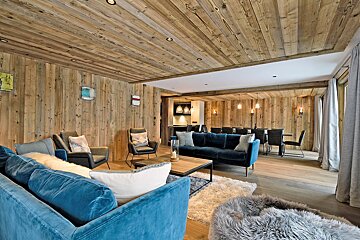 A living room with wooden walls and a blue couch