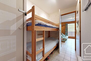 A bunk bed in a room with the word alpine on the wall