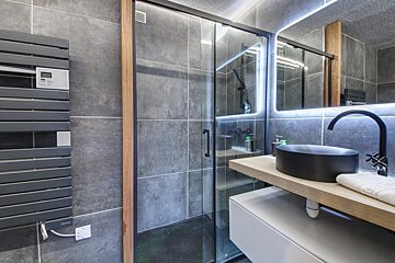 A bathroom with a black sink and a towel warmer