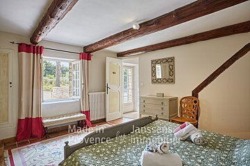 A bedroom with a bed and a dresser made in provence