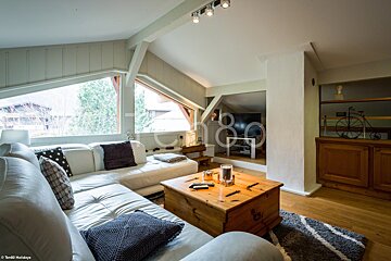 A living room with a white sectional couch and a wooden coffee table