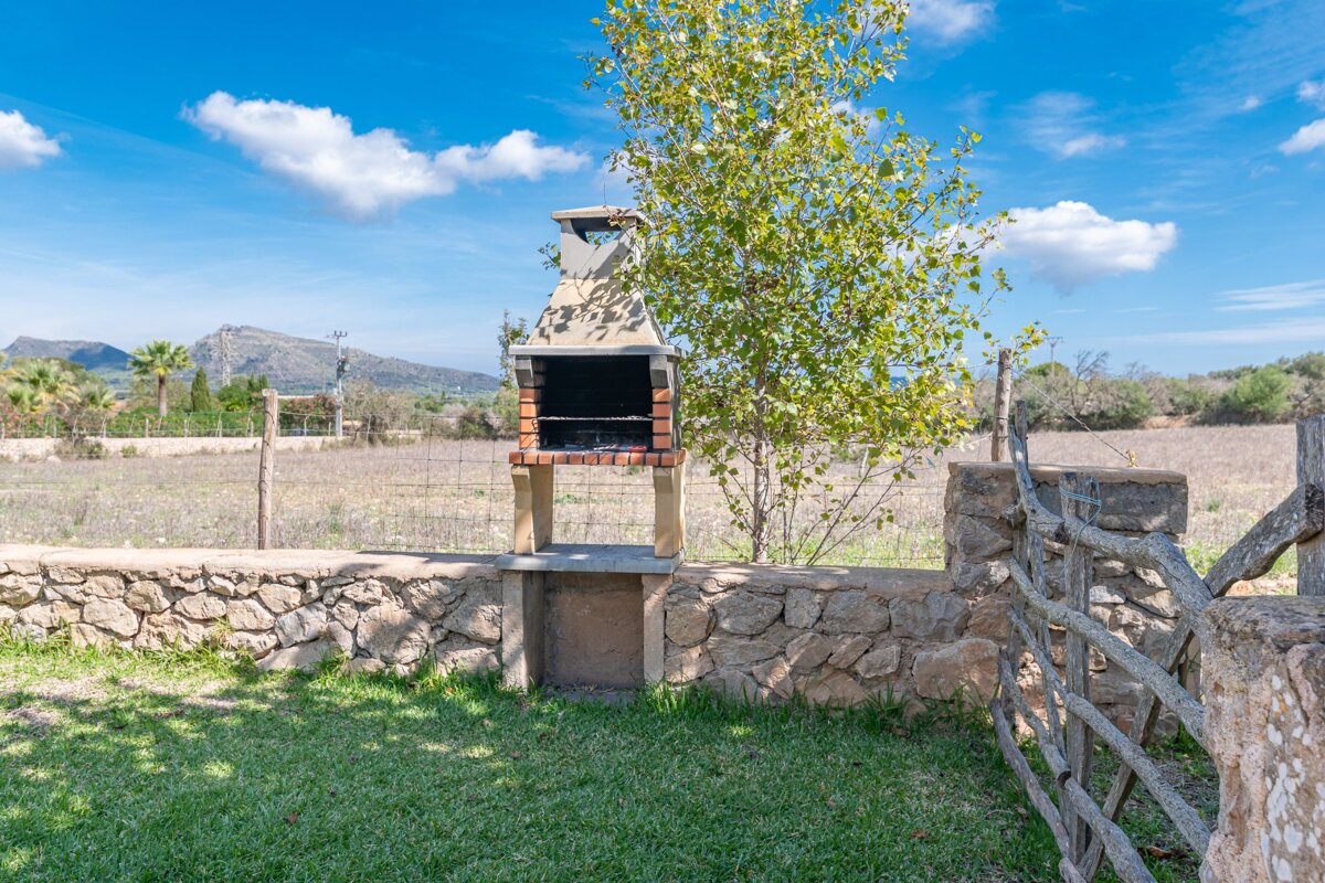 A stone wall with a brick grill in front of it