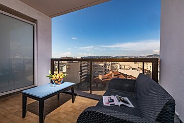 A couch on a balcony with a magazine on it