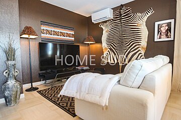 A living room with a zebra rug and the word home on the wall