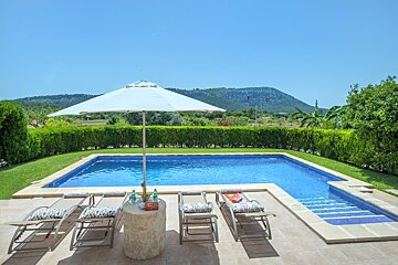 A swimming pool with a white umbrella and chairs