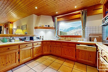 A kitchen with a view of the mountains and the word alpine on the bottom