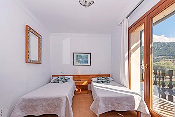 A bedroom with two beds and a picture on the wall