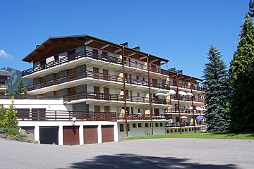 A large building with a lot of balconies and umbrellas