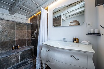 A bathroom with a sink a mirror and a shower
