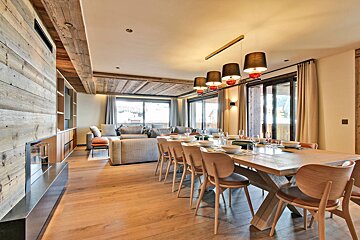 A dining room with a long wooden table and chairs