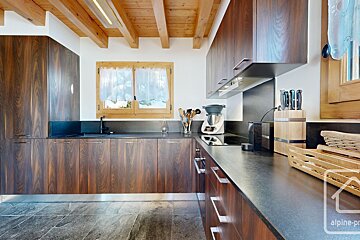 A kitchen with wooden cabinets and black counter tops