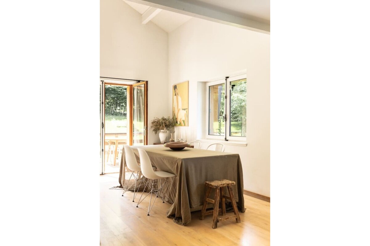 A dining room with a table and chairs and a window
