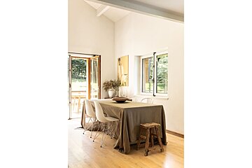 A dining room with a table and chairs and a window