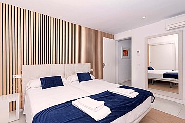 A bedroom with two beds and a mirror