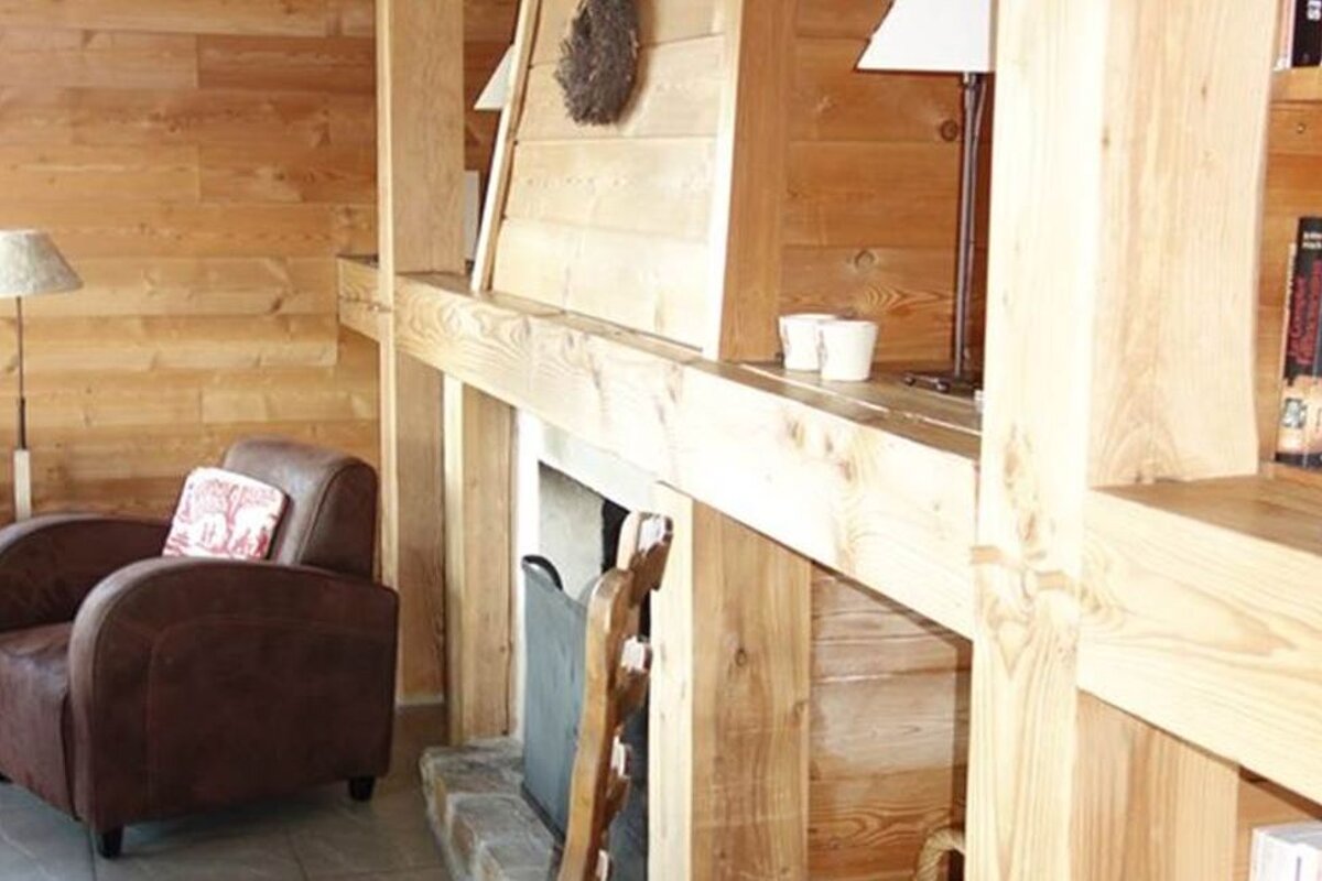 A living room with a chair and a fireplace and a bookshelf with a book that says ' french cuisine ' on it
