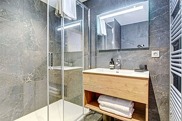 A bathroom with a sink a mirror and a towel rack
