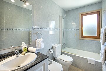 A bathroom with a toilet a sink and a window