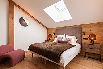 A bedroom with a large bed and a wooden headboard