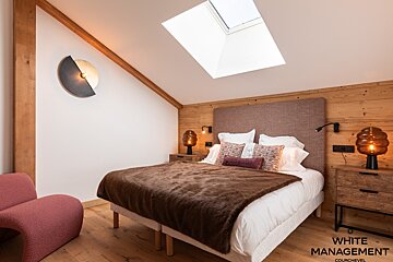A bedroom with a large bed and a wooden headboard