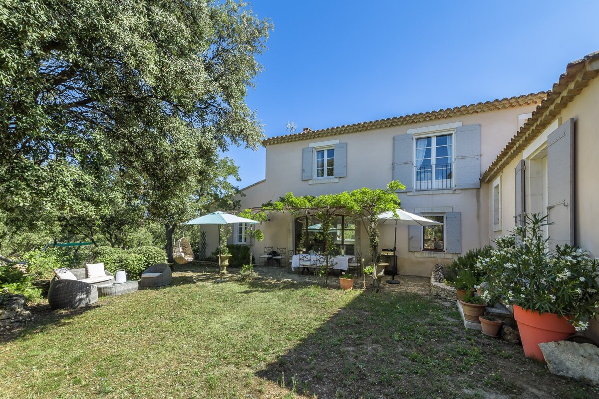 The backyard of a house with a table and chairs under an umbrella