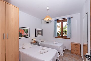 A bedroom with two beds and two pictures on the wall