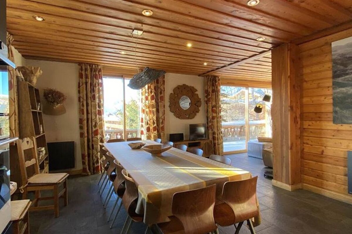 A dining room with a long table and chairs