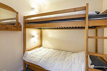 A bunk bed in a bedroom with a mirror above it