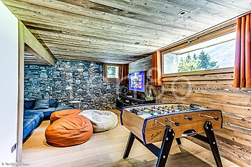 A game room with a foosball table and bean bag chairs