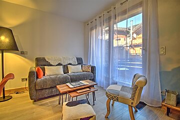 A living room with a couch a table and a chair