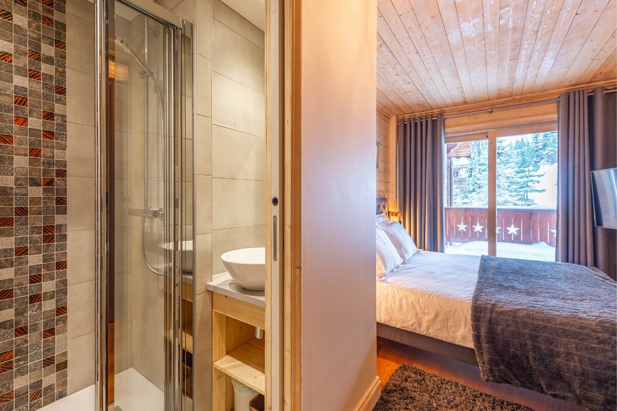 A bedroom with a king size bed and a walk in shower