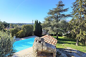 A stone chimney sits next to a swimming pool