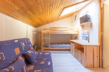A bedroom with bunk beds and a blue couch