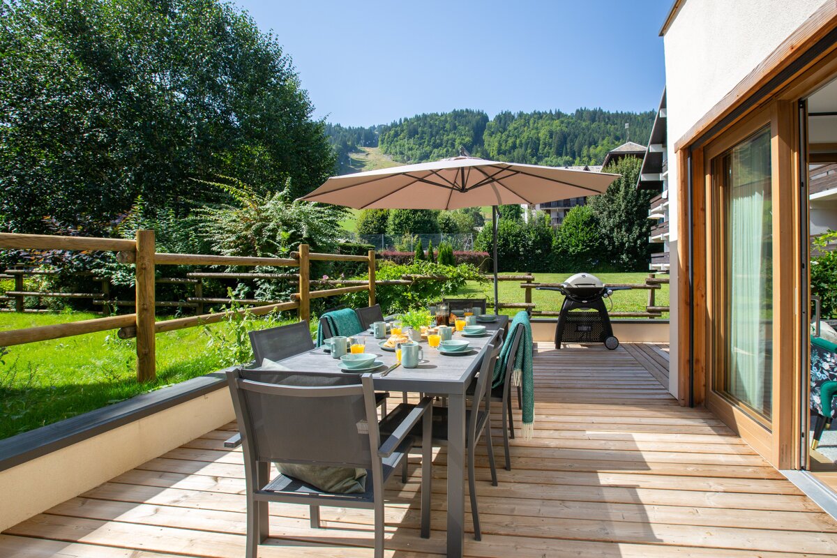 A patio with a table and chairs and an umbrella