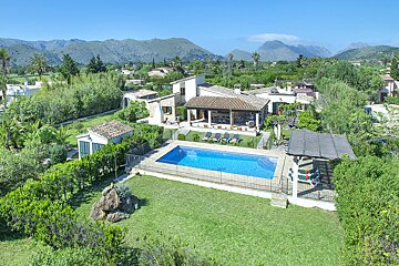An aerial view of a house with a large swimming pool